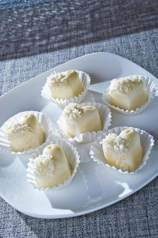 bombones de chocolate blanco en forma de corazón sobre el mantel foto