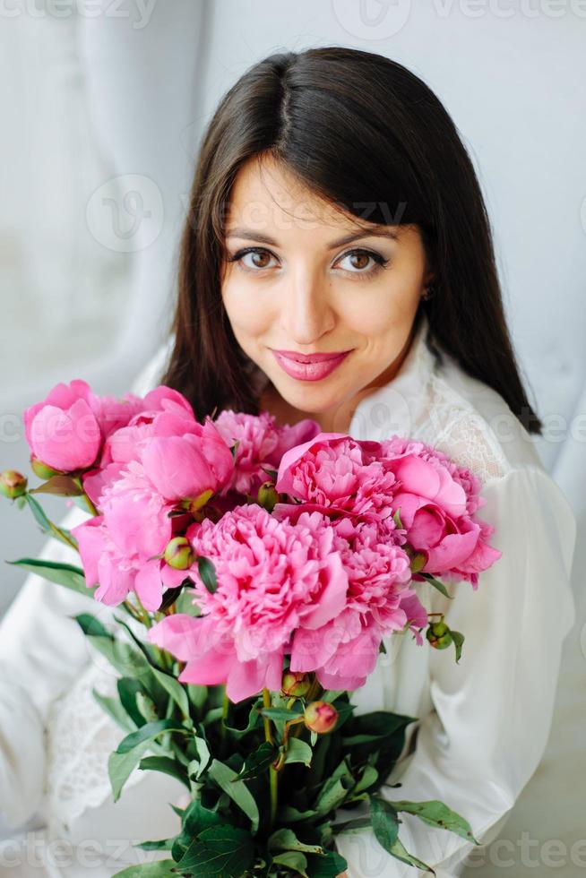 retrato de estudio de belleza. mujer modelo romántica con flores de peonía. disparo de alta moda. foto