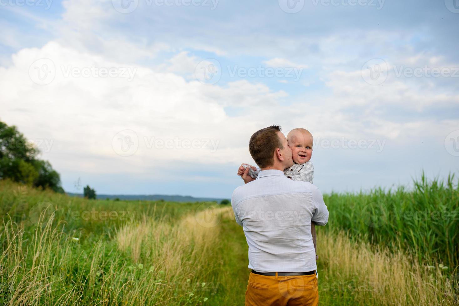 Father and mother lead their one-year-old son by the hand. photo