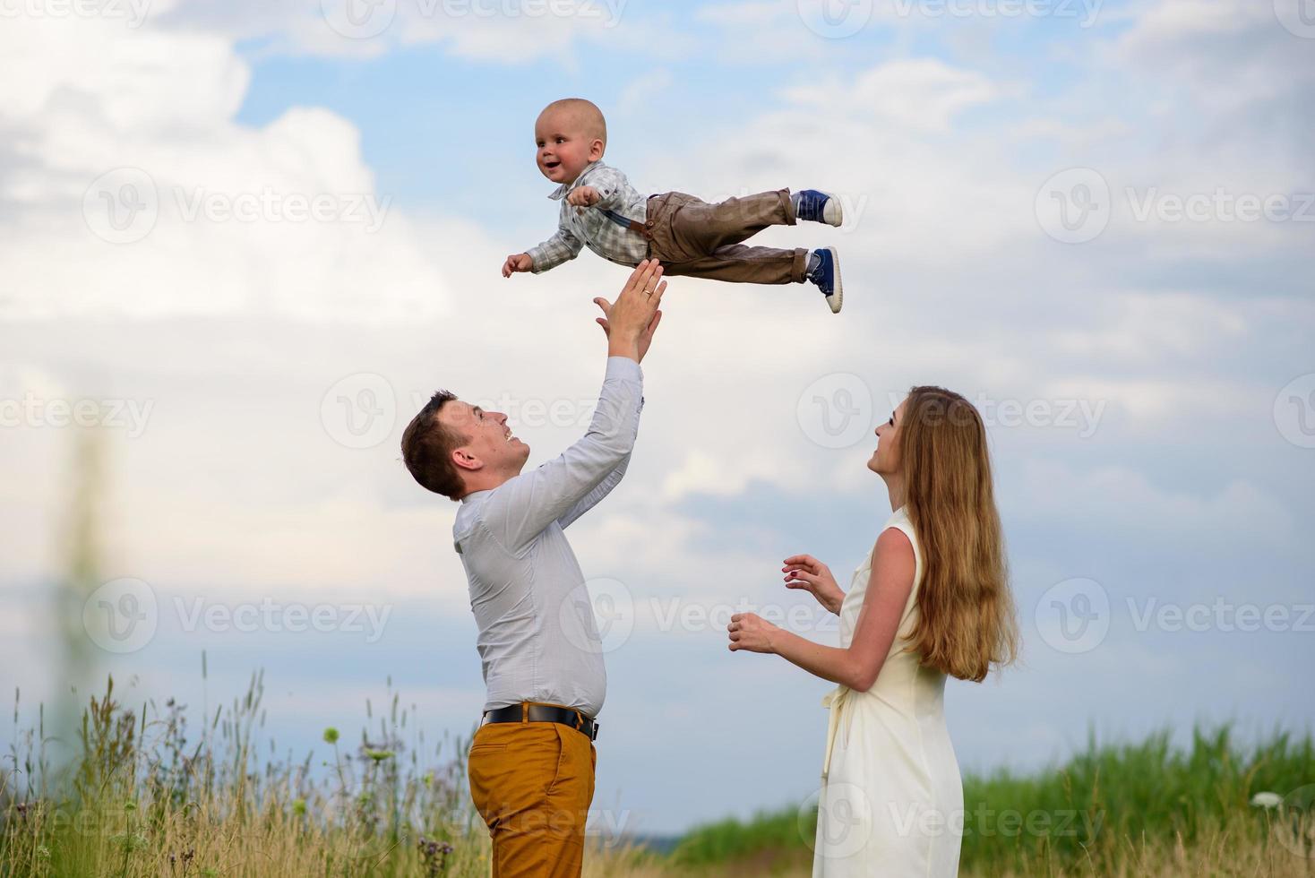 Father and mother lead their one-year-old son by the hand. photo