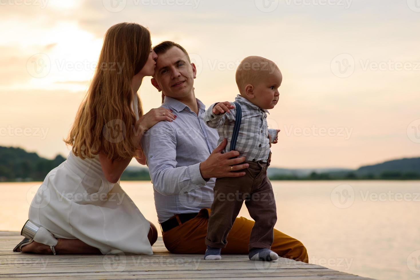 padre y madre llevan de la mano a su hijo de un año. foto