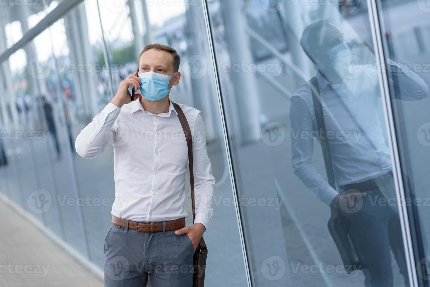 The fired office worker fell to his knees and covered his face due to stress. In front of him is a cardboard box with stationery. The man is unhappy due to a reduction in the robot. photo