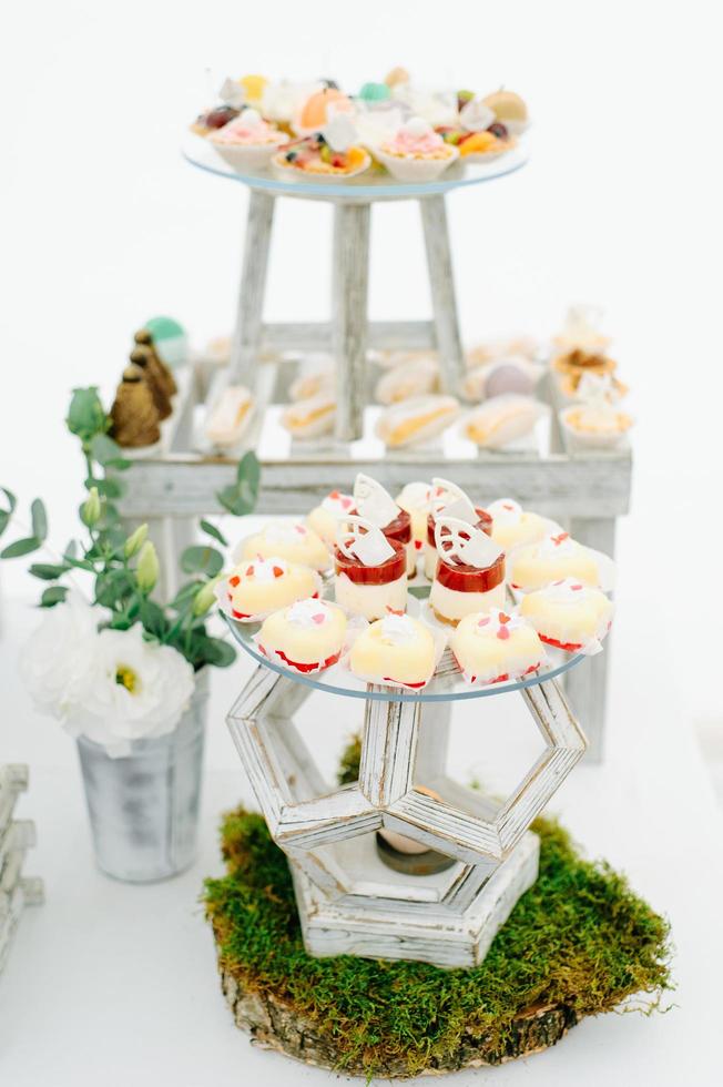 Round dinner tables covered with blue cloth stand in a white wedding pavilion photo