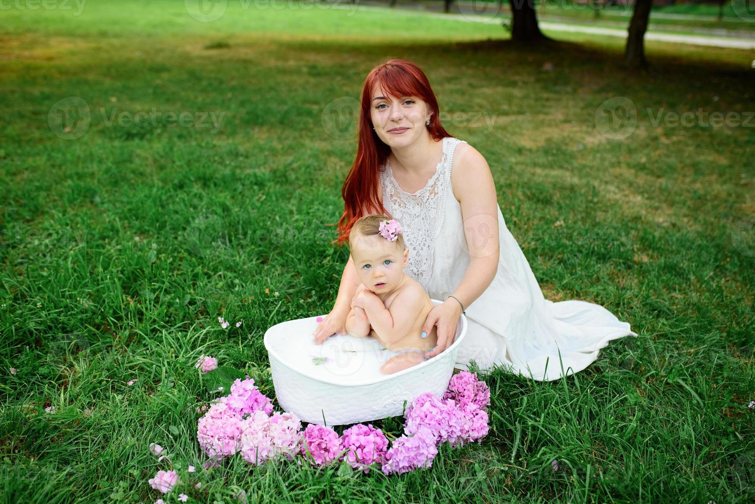 Mom helps her little oneyearold daughter bathe in the bathroom