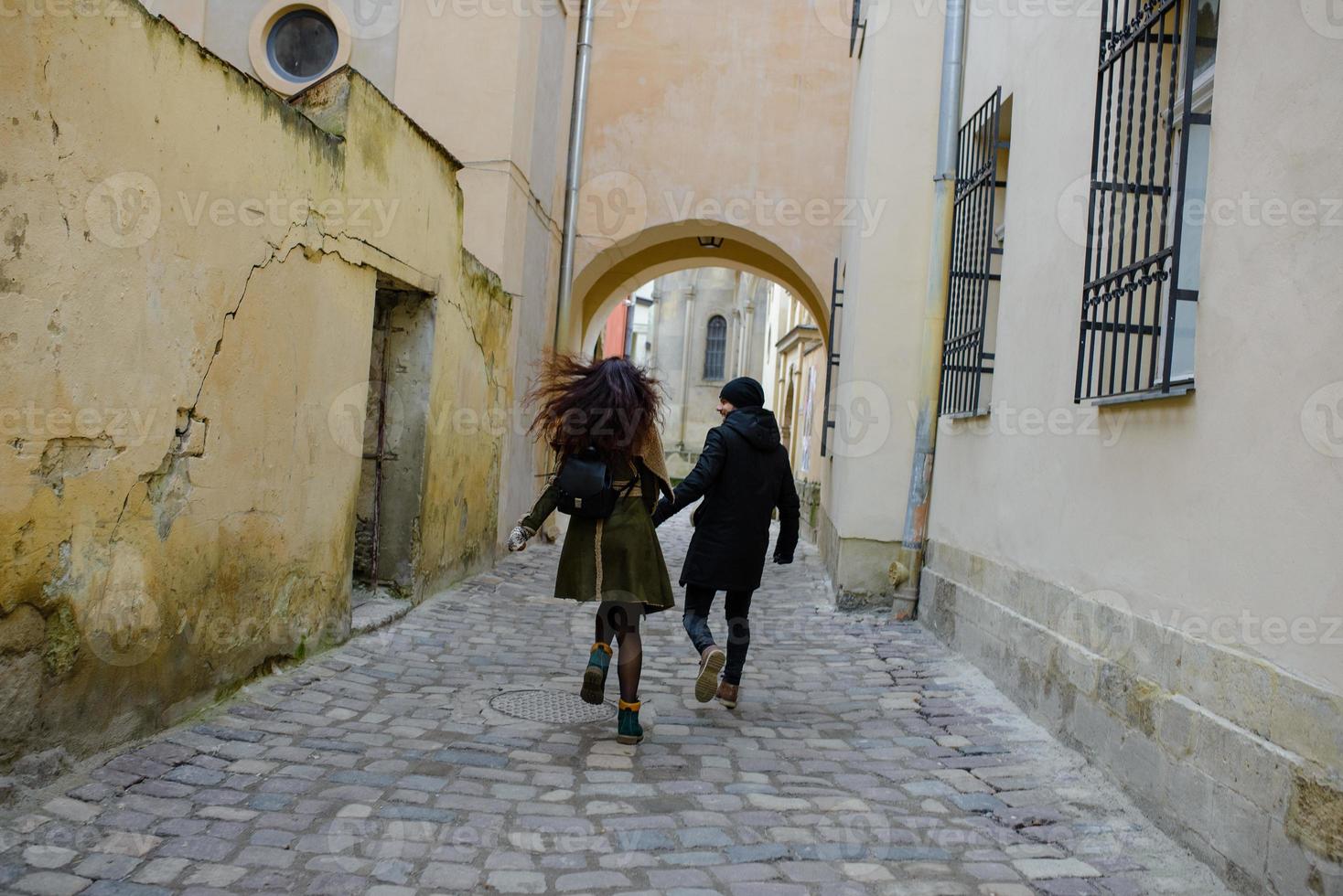 joven pareja amorosa vestida con un estilo informal camina por la ciudad vieja en invierno foto