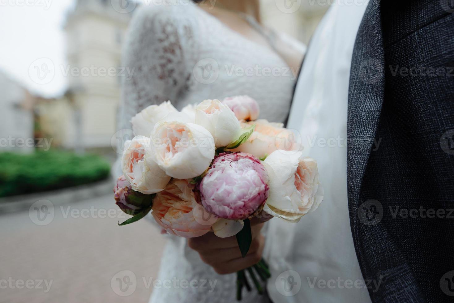 bride with flowers in hand outdoors. photo