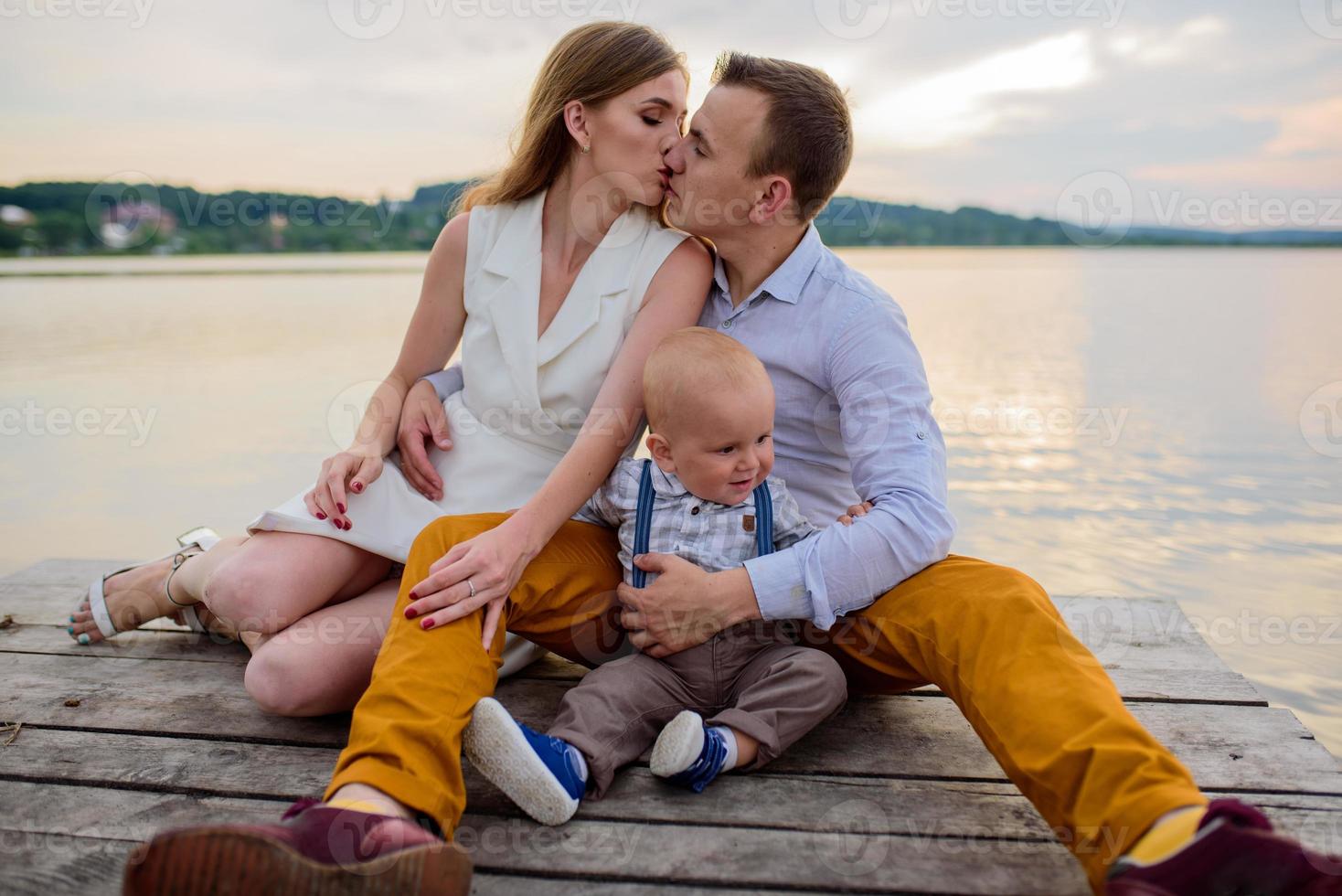 Father and mother lead their one-year-old son by the hand. photo