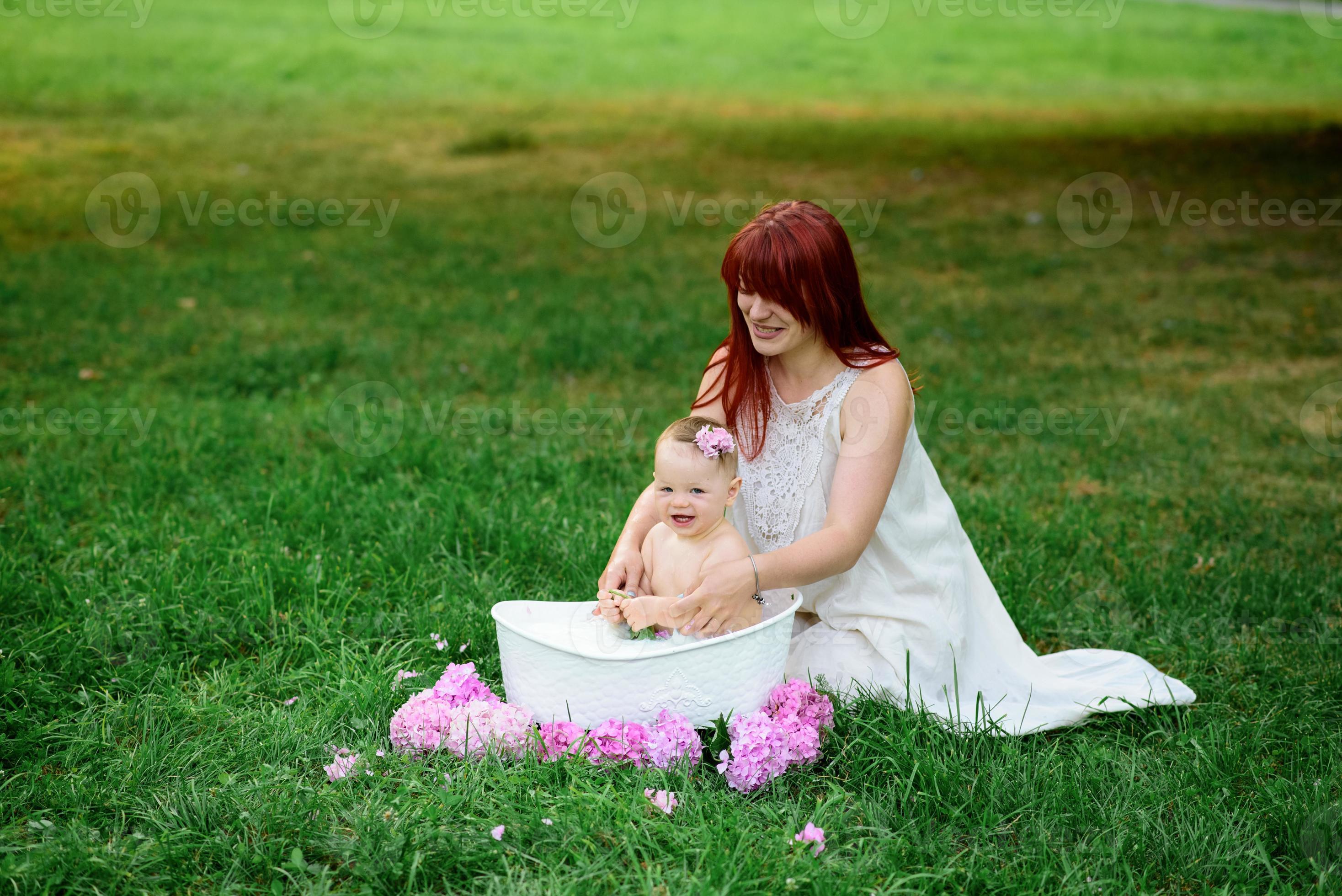 Mom helps her little oneyearold daughter bathe in the bathroom