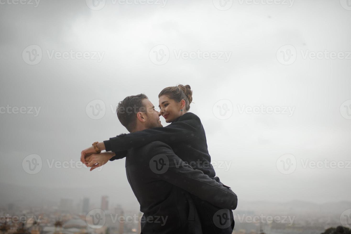 Young beautiful loving Hispanic couple walks under an umbrella during the rain. photo