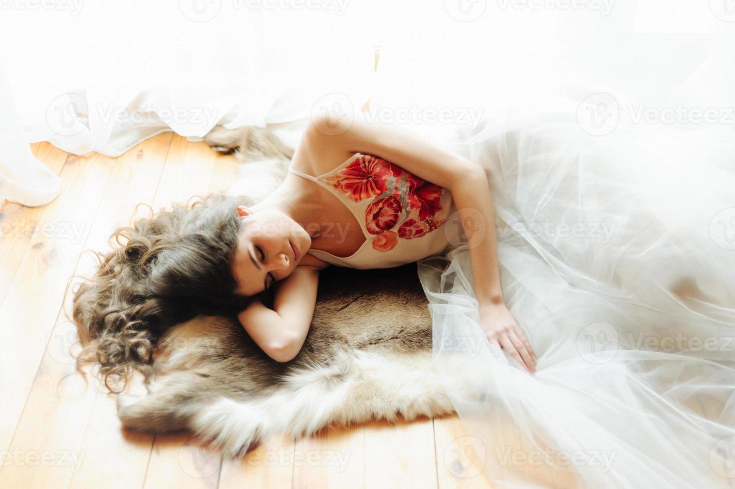 Beautiful girl in penuar lying on bed photo