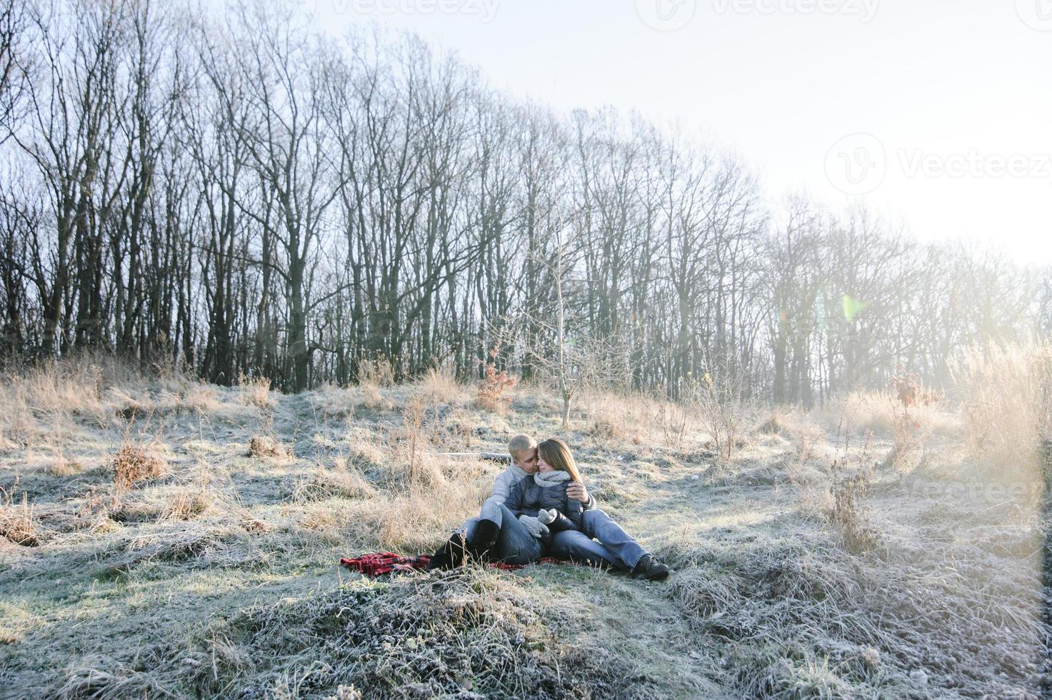 Young pretty fashion sensual couple in love sitting in winter cold field photo