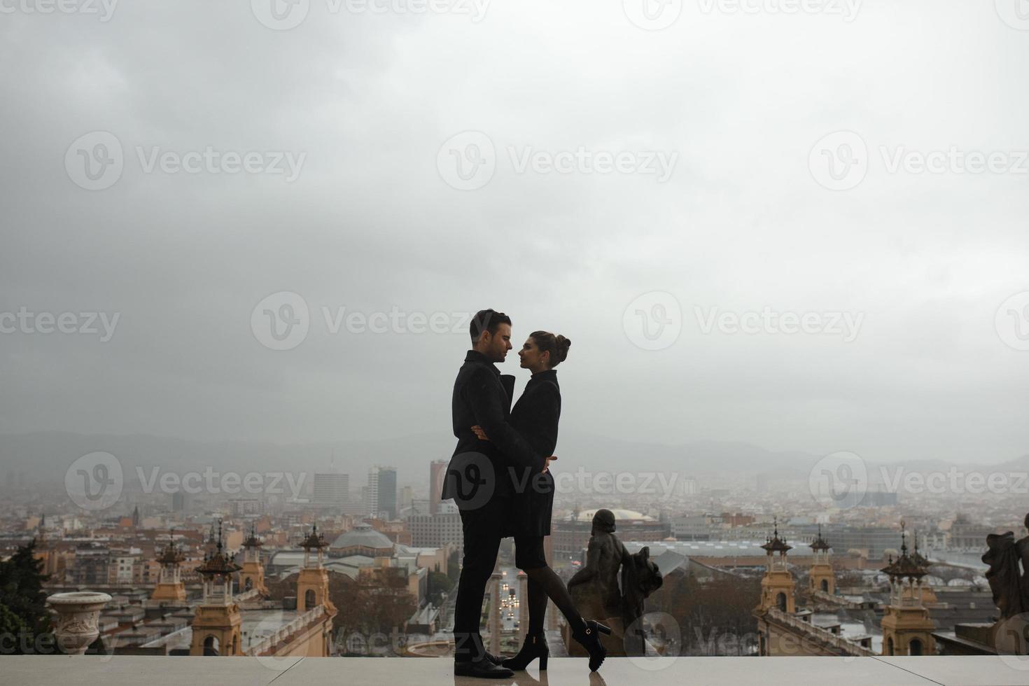 joven hermosa pareja hispana amorosa camina bajo un paraguas durante la lluvia. foto