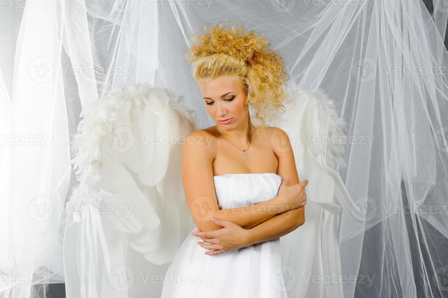 mujer sexy disfrazada de ángel posando frente a la cámara. foto