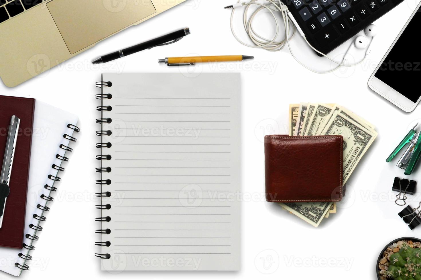 White office desk with smartphone with black screen, pen, laptop computer, wallet, and supplies. Top view with copy space. photo