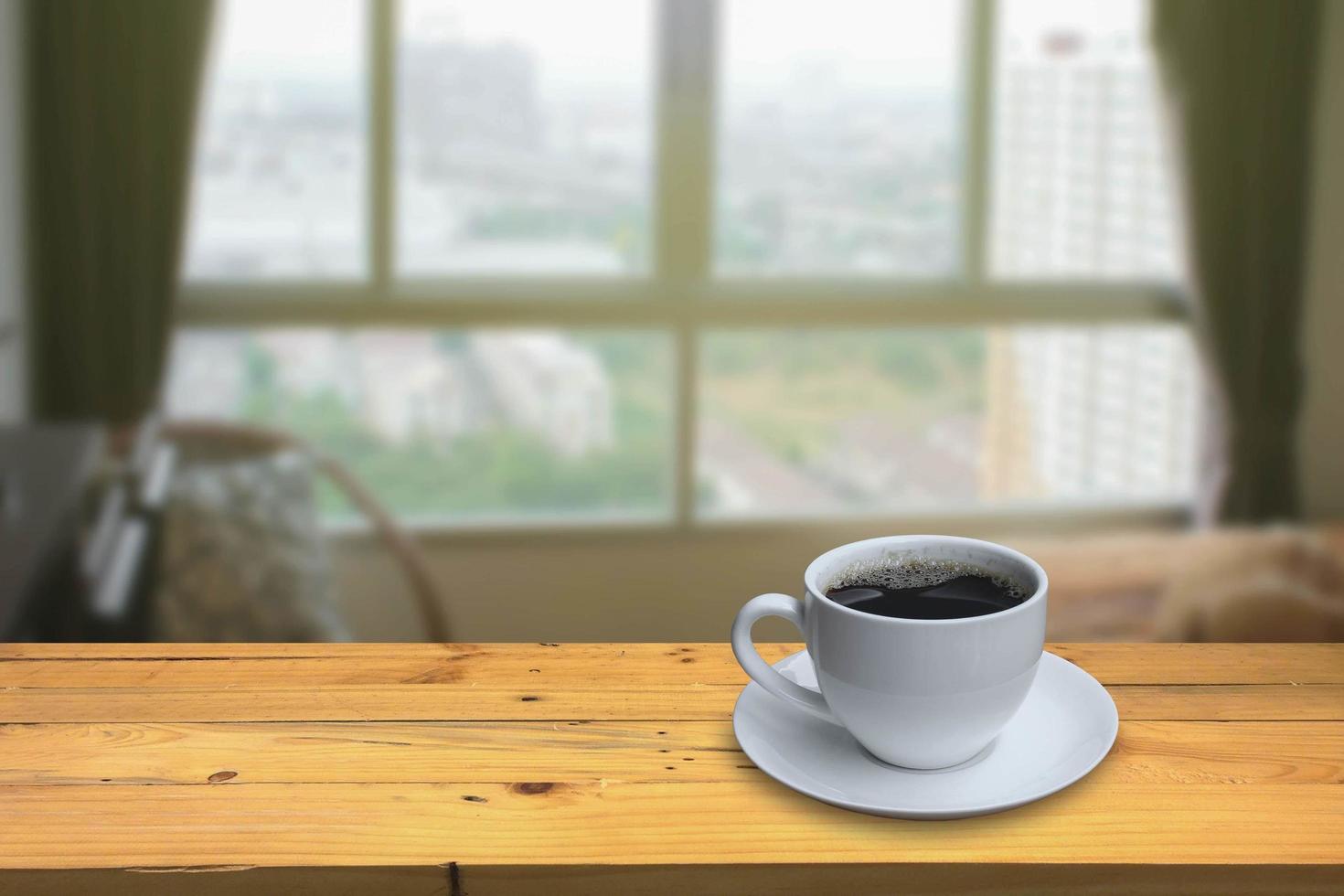 taza de café en el suelo de madera y fondo borroso de la ventana del dormitorio foto