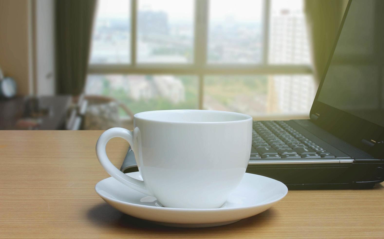 taza de café en el suelo de madera y fondo borroso de la ventana del dormitorio foto