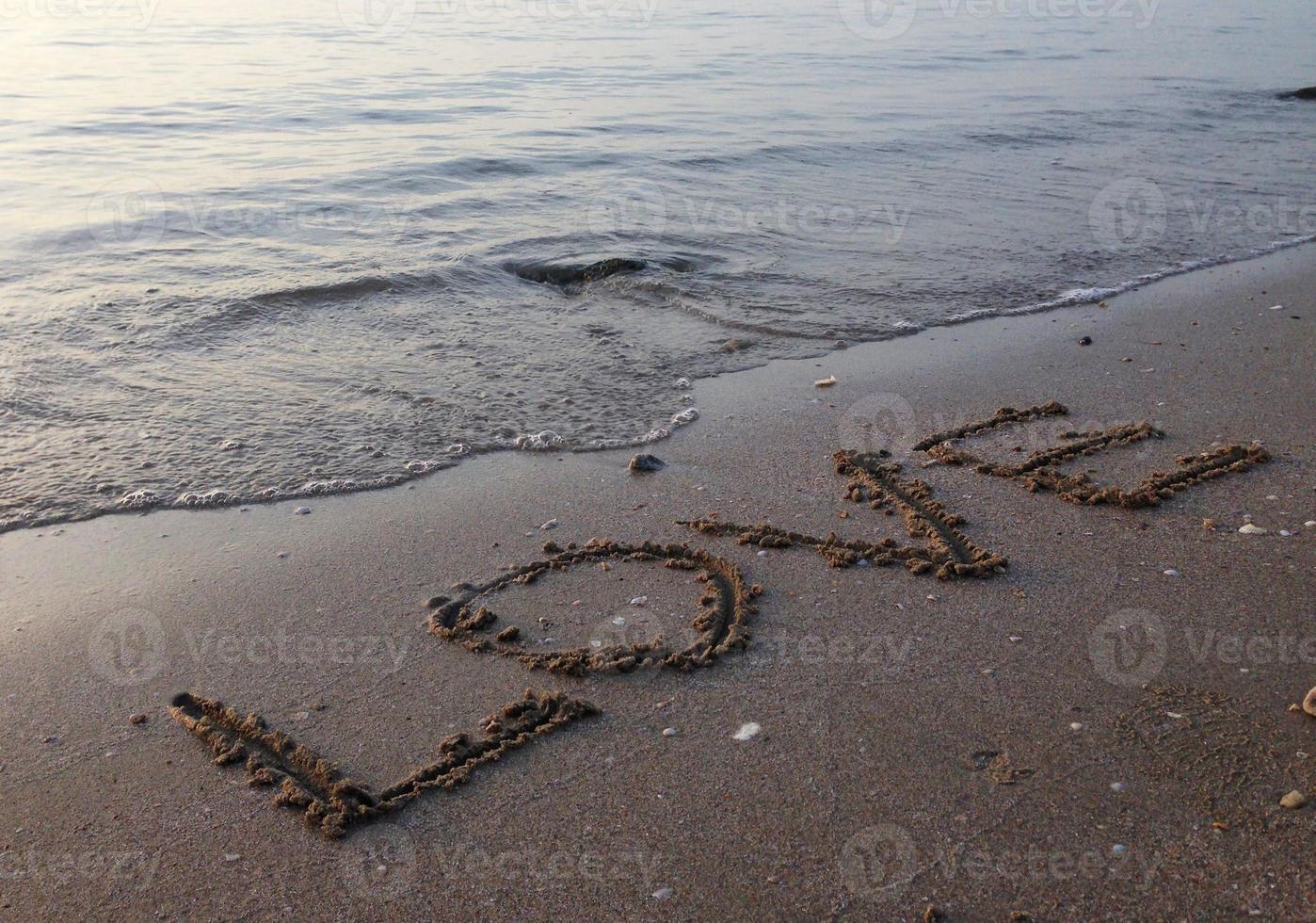 Beach sea water on the beach written on sand, love photo