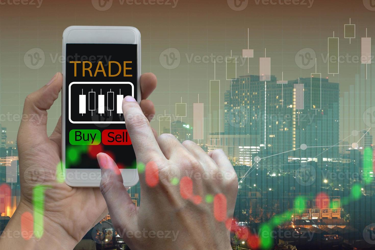 Hand use smartphone trading online on screen with Candle stick graph chart of stock market and city background photo