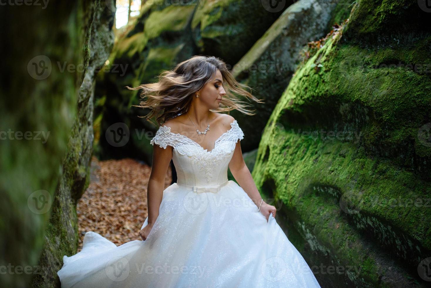 la novia y el novio. una pareja paseando entre el estrecho y hermoso desfiladero. el desfiladero estaba cubierto de musgo verde. los recién casados giran y corren. foto