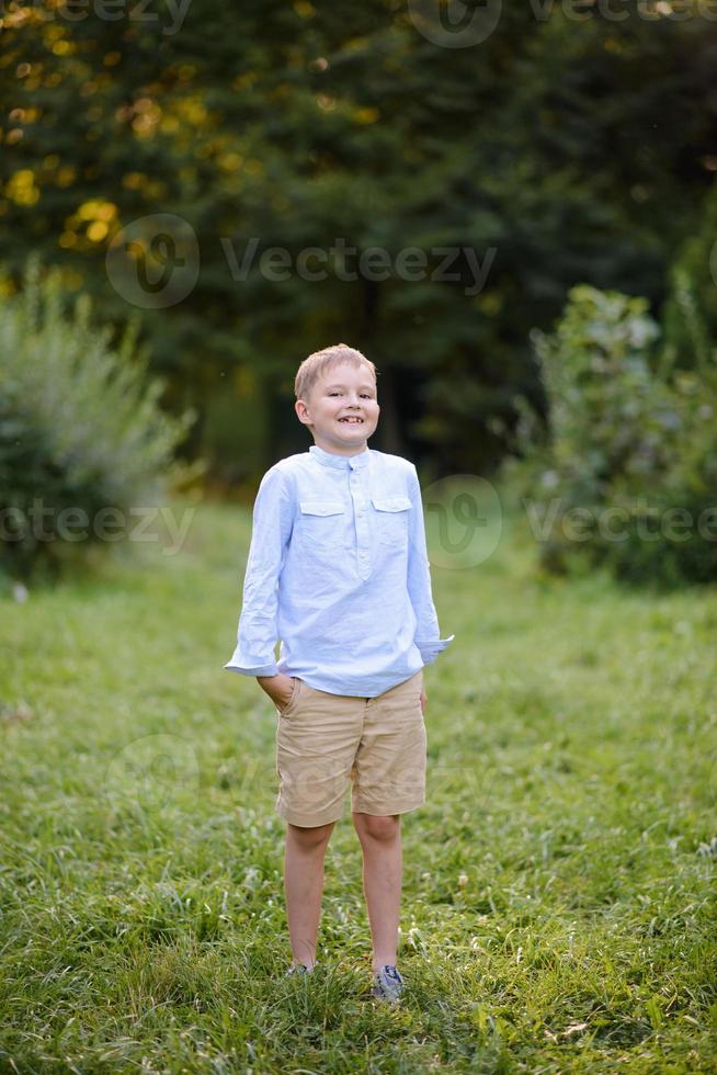 A boy of primary school age runs with balloons. The boy celebrates his birthday in the park. photo