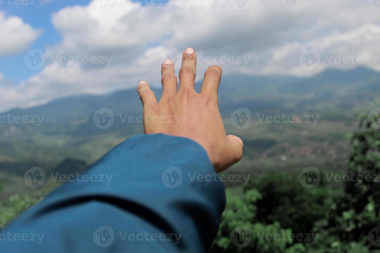 left hand with a beautiful mountain view photo