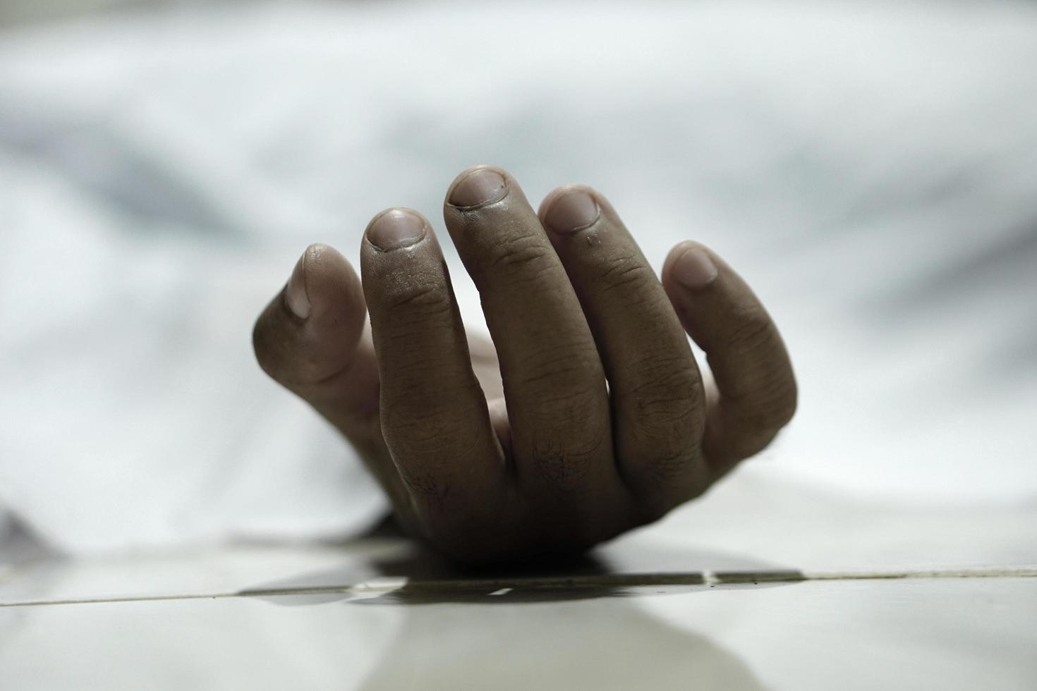 dead body laying on a floor.Focus at the hand photo