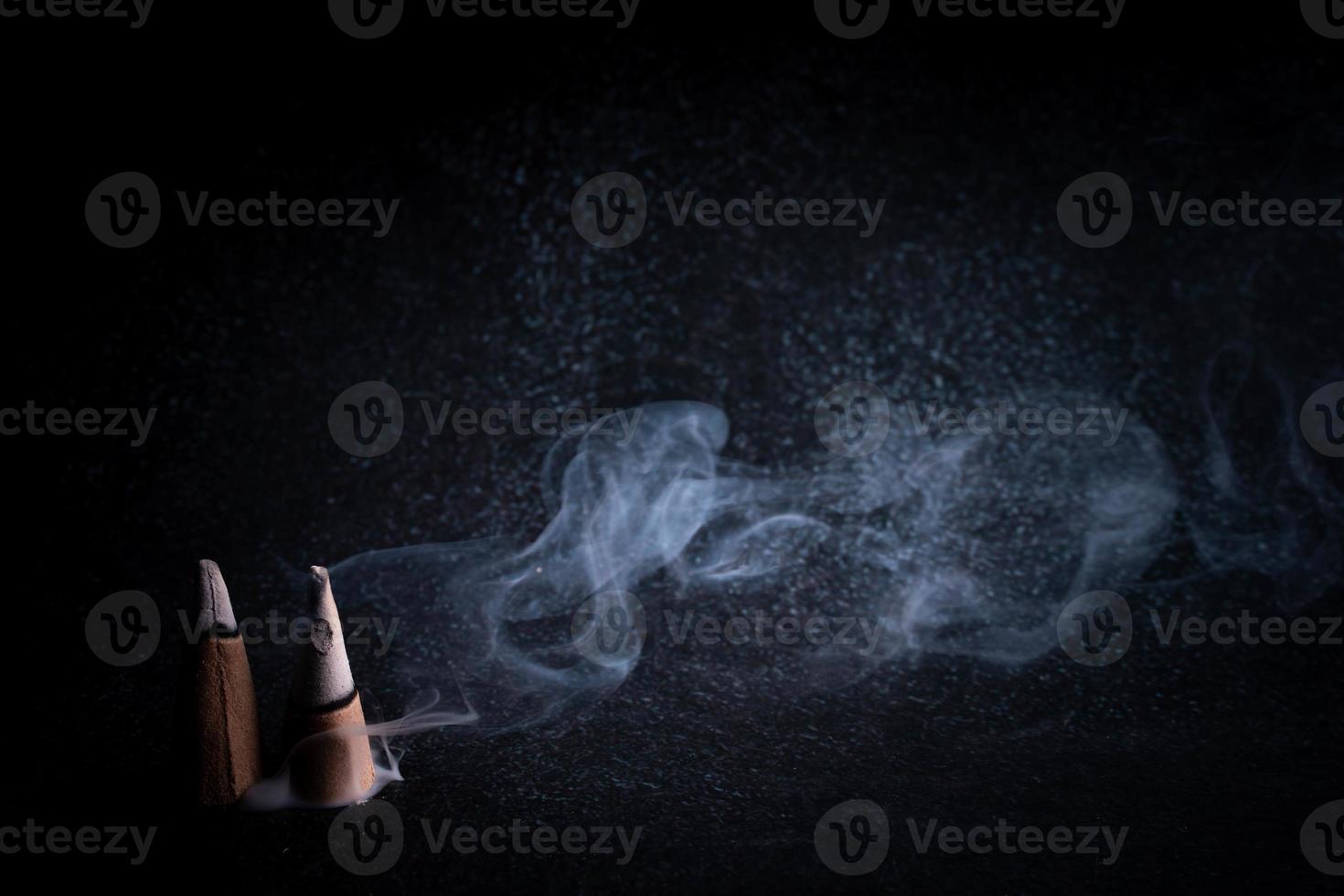 incense and smoke on black background photo