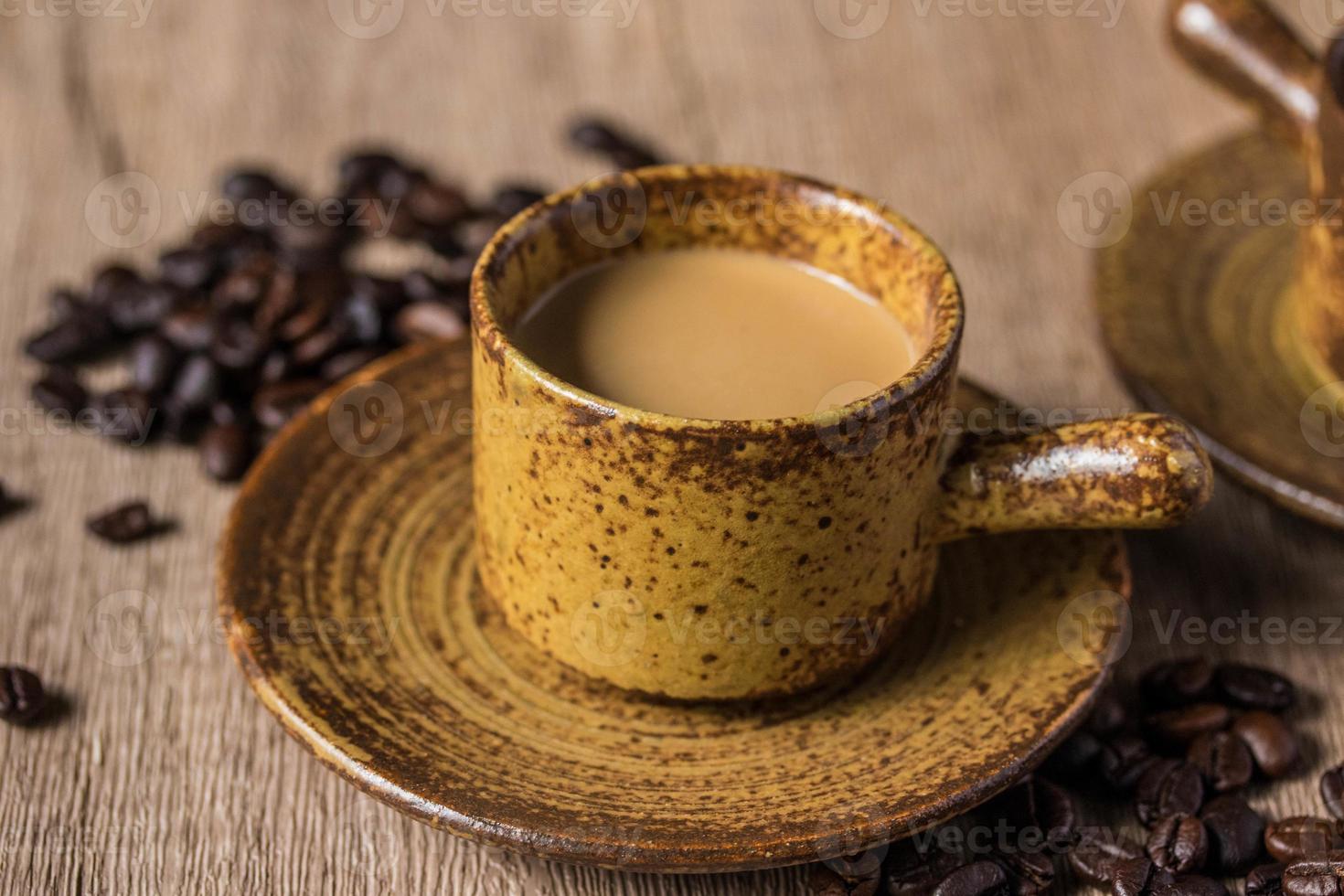 café caliente en taza marrón sobre fondo de madera foto