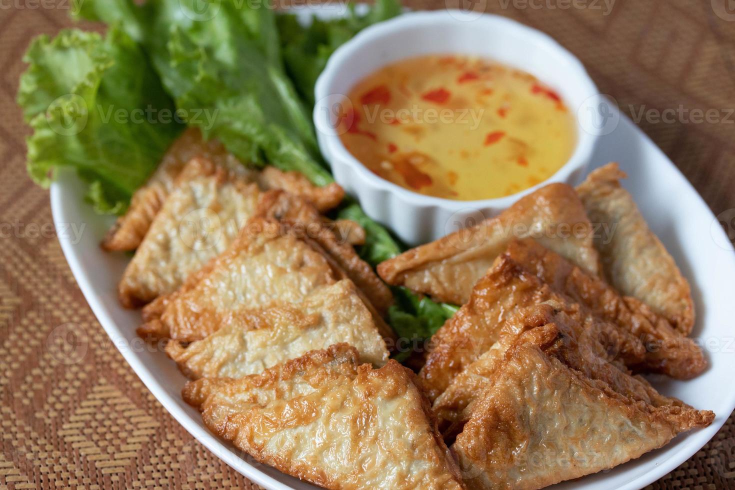 Triangular fried tofu eating with spicy dipping sauce, sweet and spicy photo