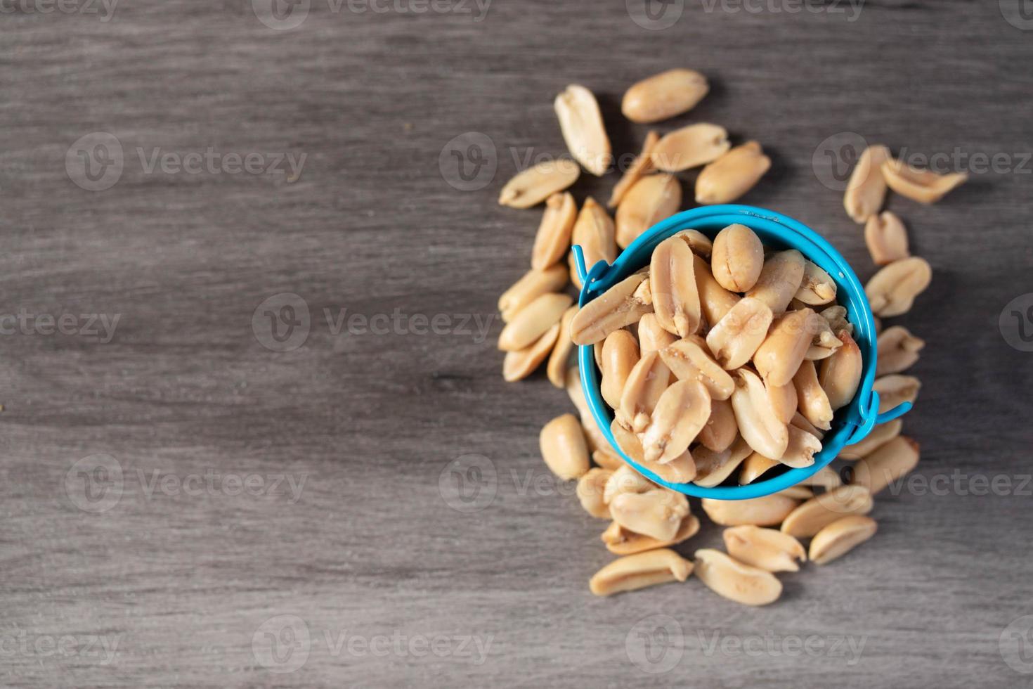 Baked peanuts in a bucket on a wooden background photo