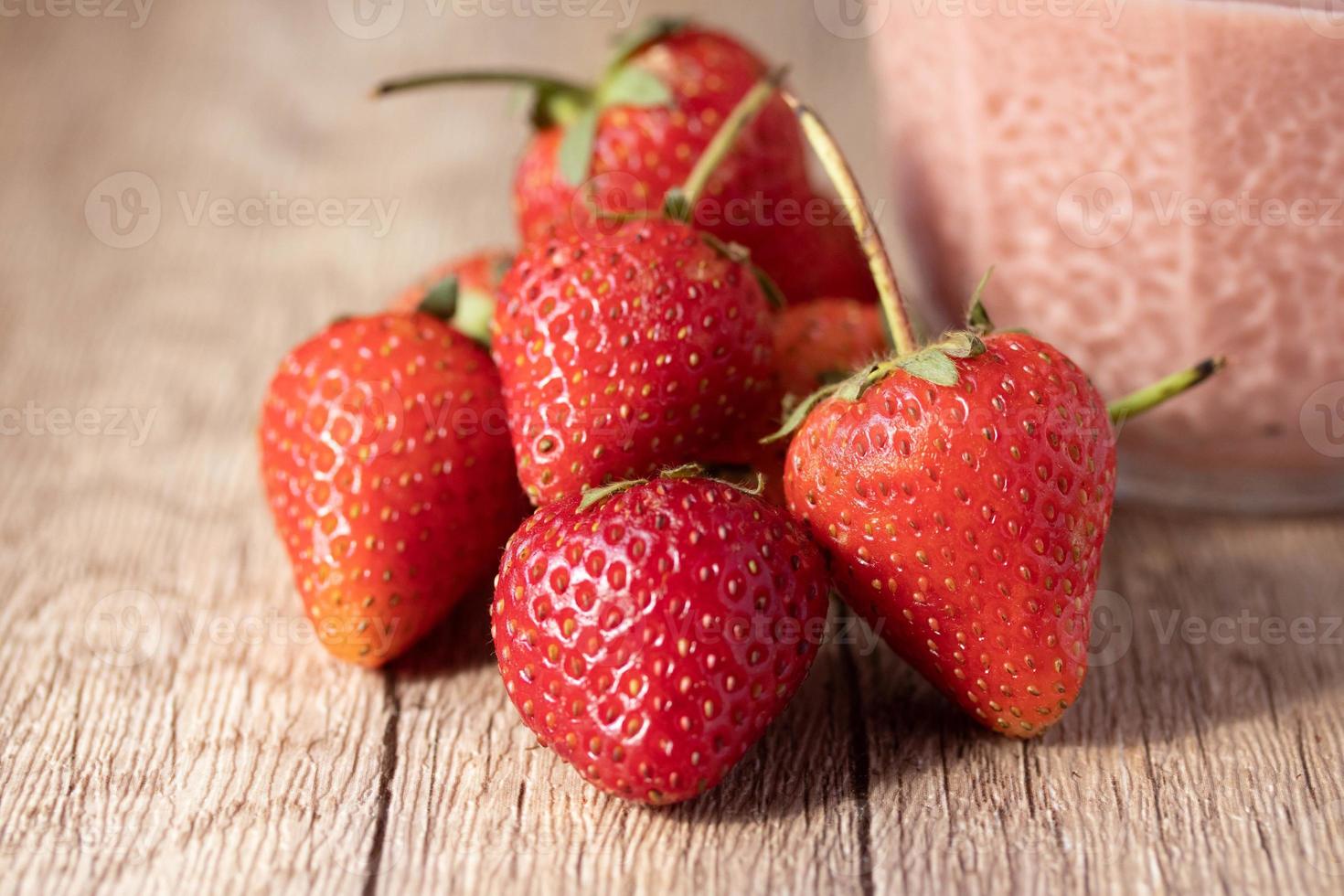 strawberries in a wicker basket on brown background photo