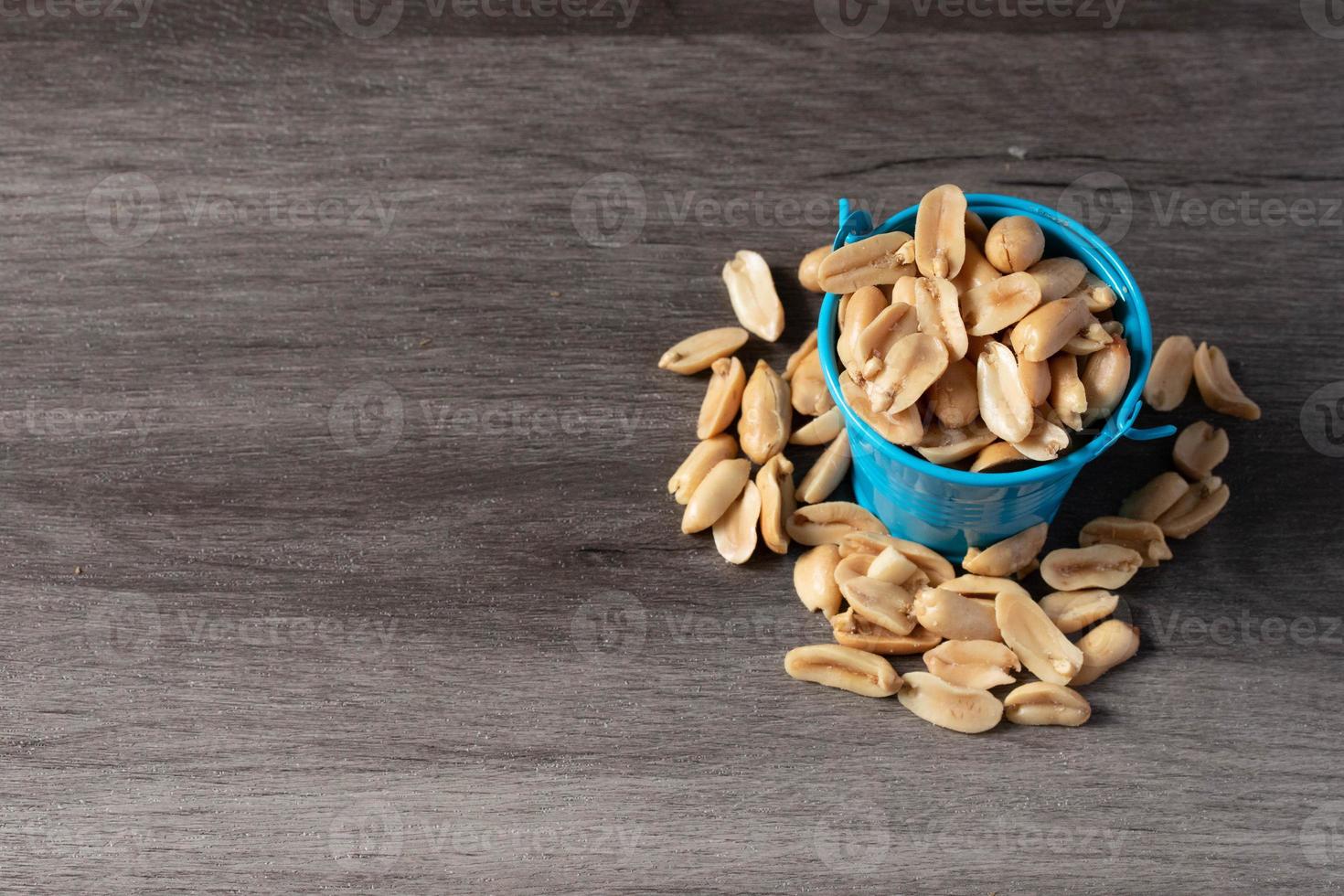 Baked peanuts in a bucket on a wooden background photo