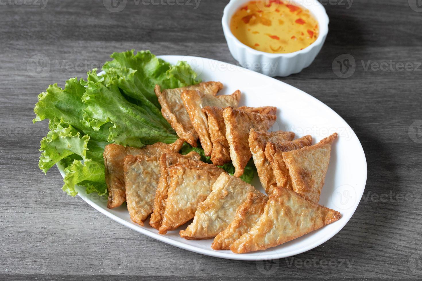 Triangular fried tofu eating with spicy dipping sauce, sweet and spicy photo
