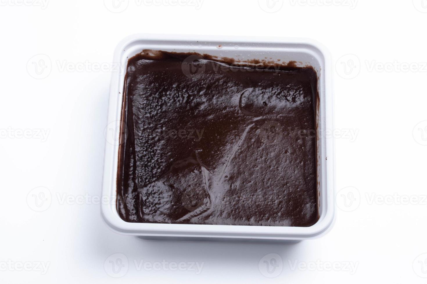 Chocolate cake is shown in a square box.On a white background. photo