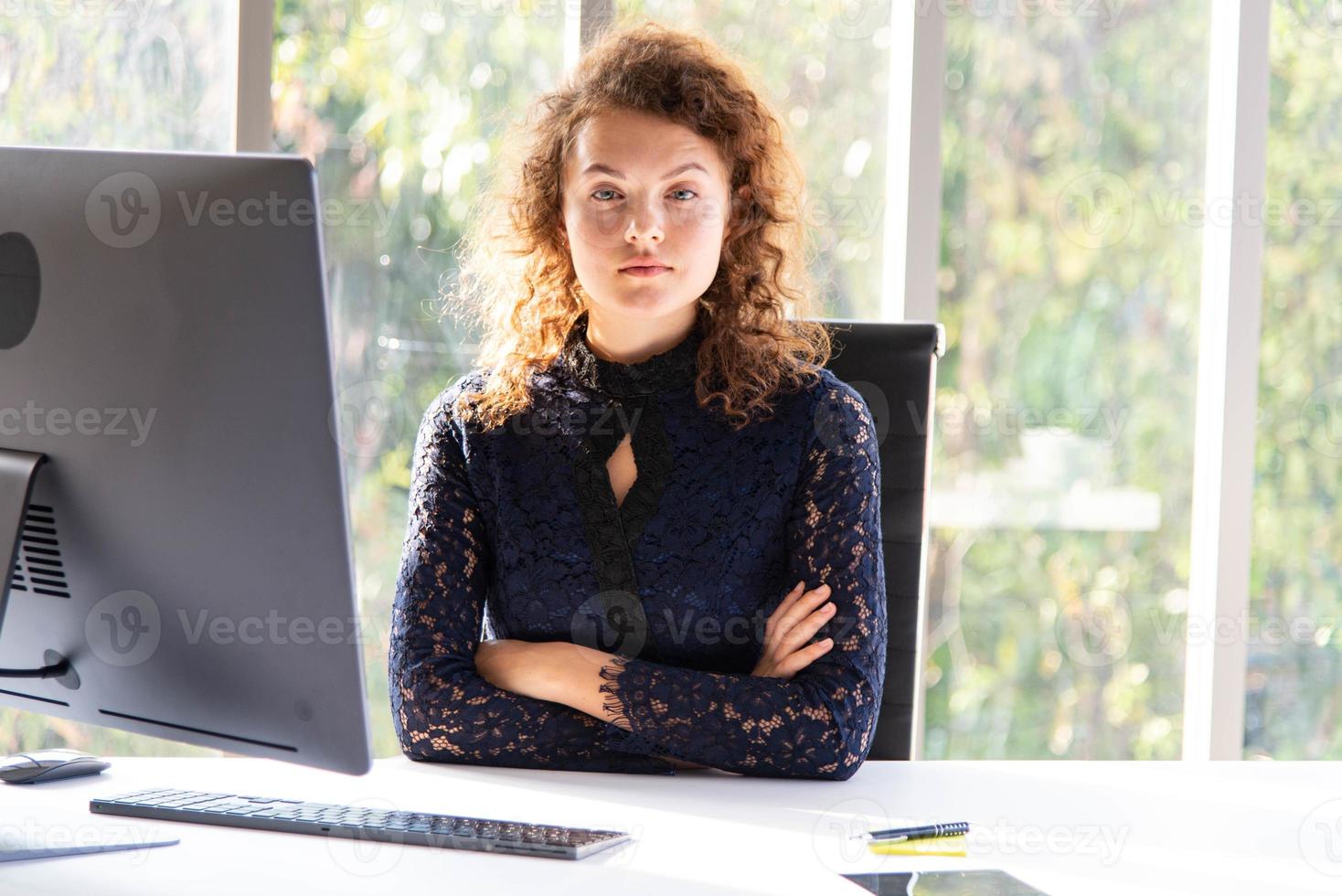 atractiva mujer de negocios hermosa y segura de sí misma que trabaja con una computadora en la oficina o el hogar modernos foto