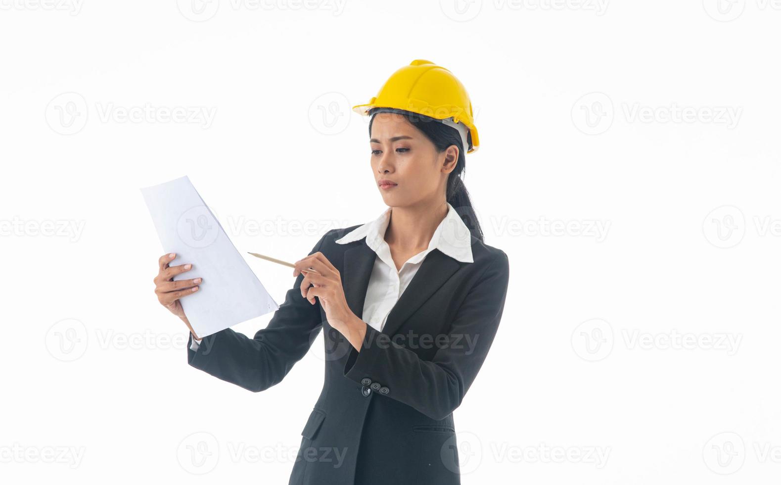 Young engineer woman wear black suit and yellow safety helmet holding note on isolated white background. photo