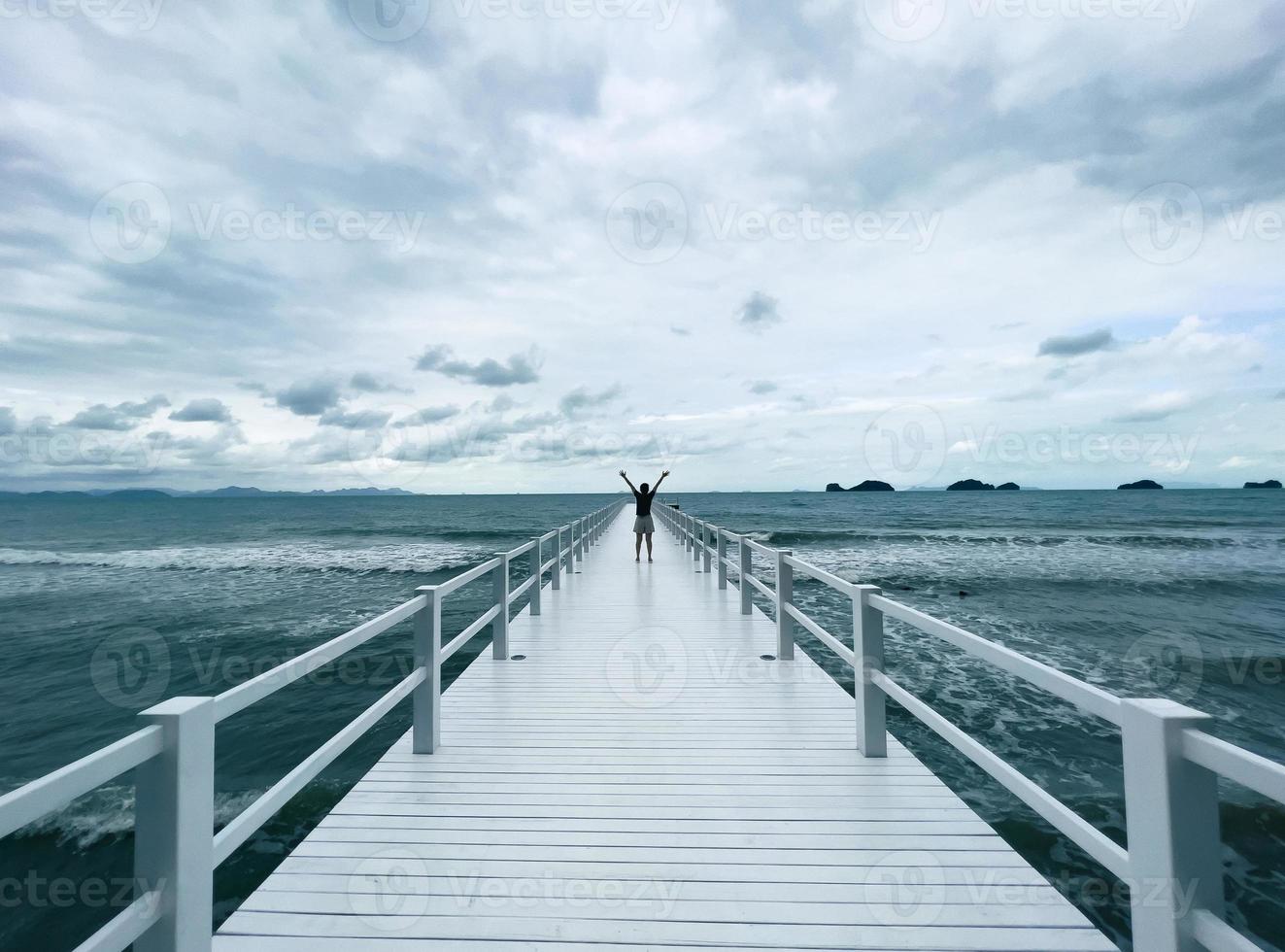 Adult Woman Standing on White Bridge on Sea in Moody Day photo