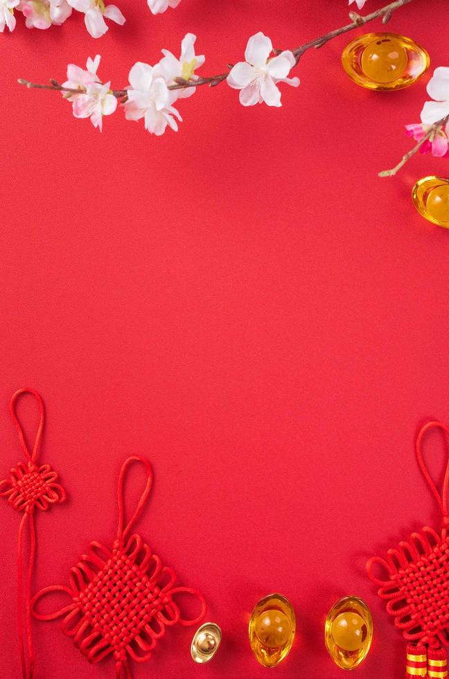 Design concept of Chinese lunar new year - Beautiful Chinese knot with plum blossom isolated on red background, flat lay, top view, overhead layout. photo