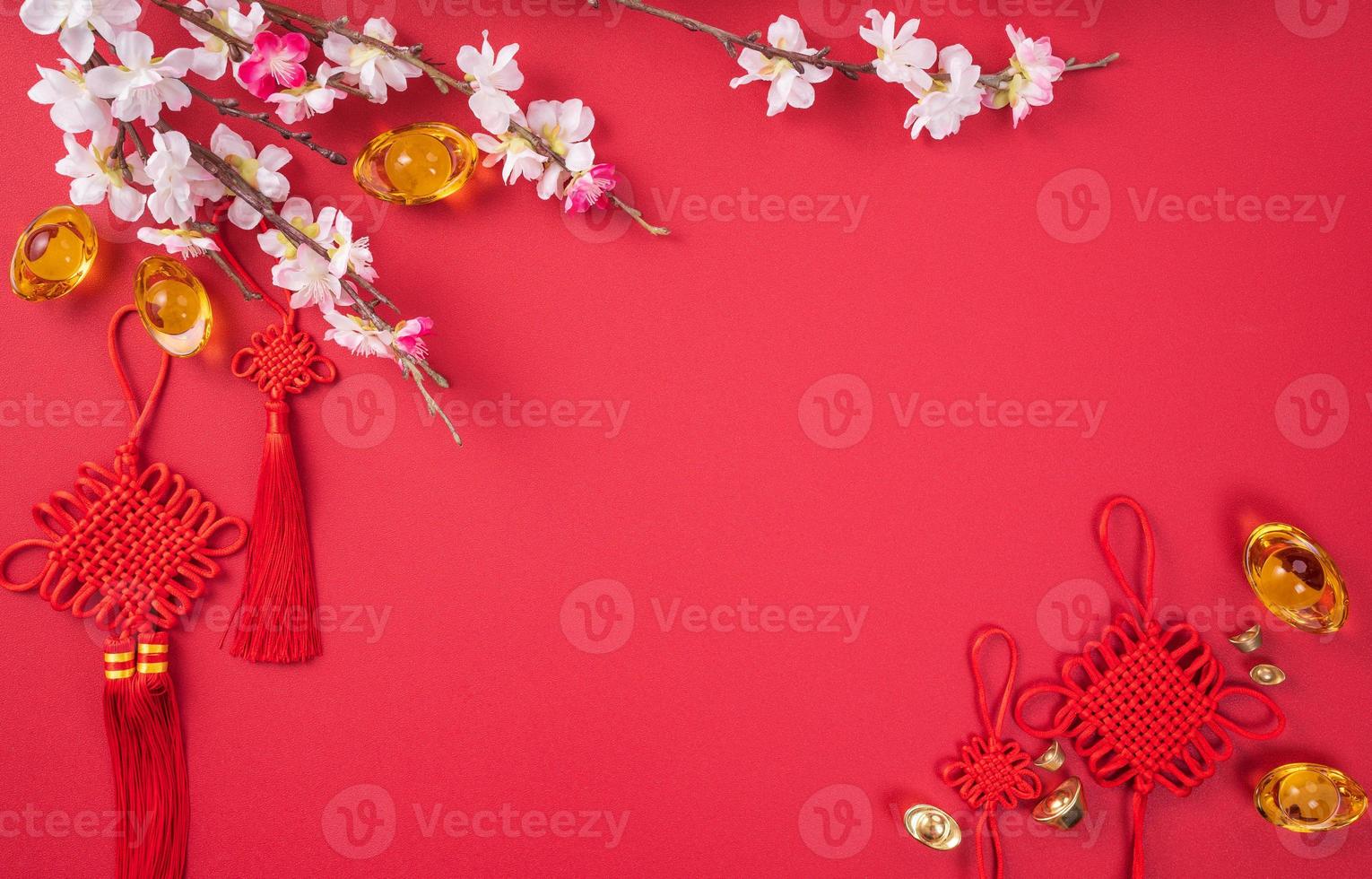 Design concept of Chinese lunar new year - Beautiful Chinese knot with plum blossom isolated on red background, flat lay, top view, overhead layout. photo