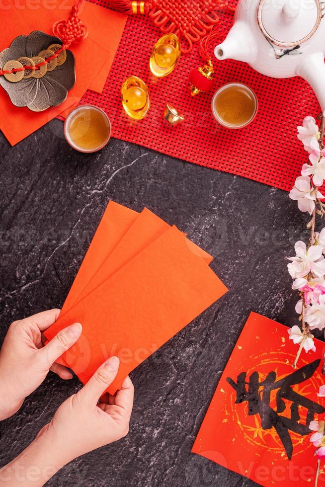 Design concept of Chinese lunar January new year - Woman holding, giving red envelopes ang pow, hong bao for lucky money, top view, flat lay, overhead above. The word 'chun' means coming spring. photo