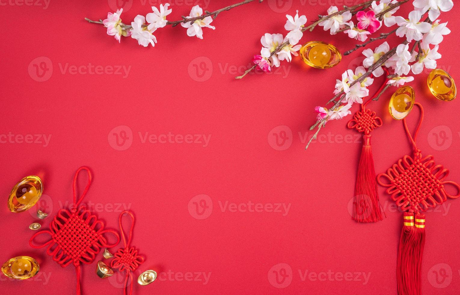 Design concept of Chinese lunar new year - Beautiful Chinese knot with plum blossom isolated on red background, flat lay, top view, overhead layout. photo