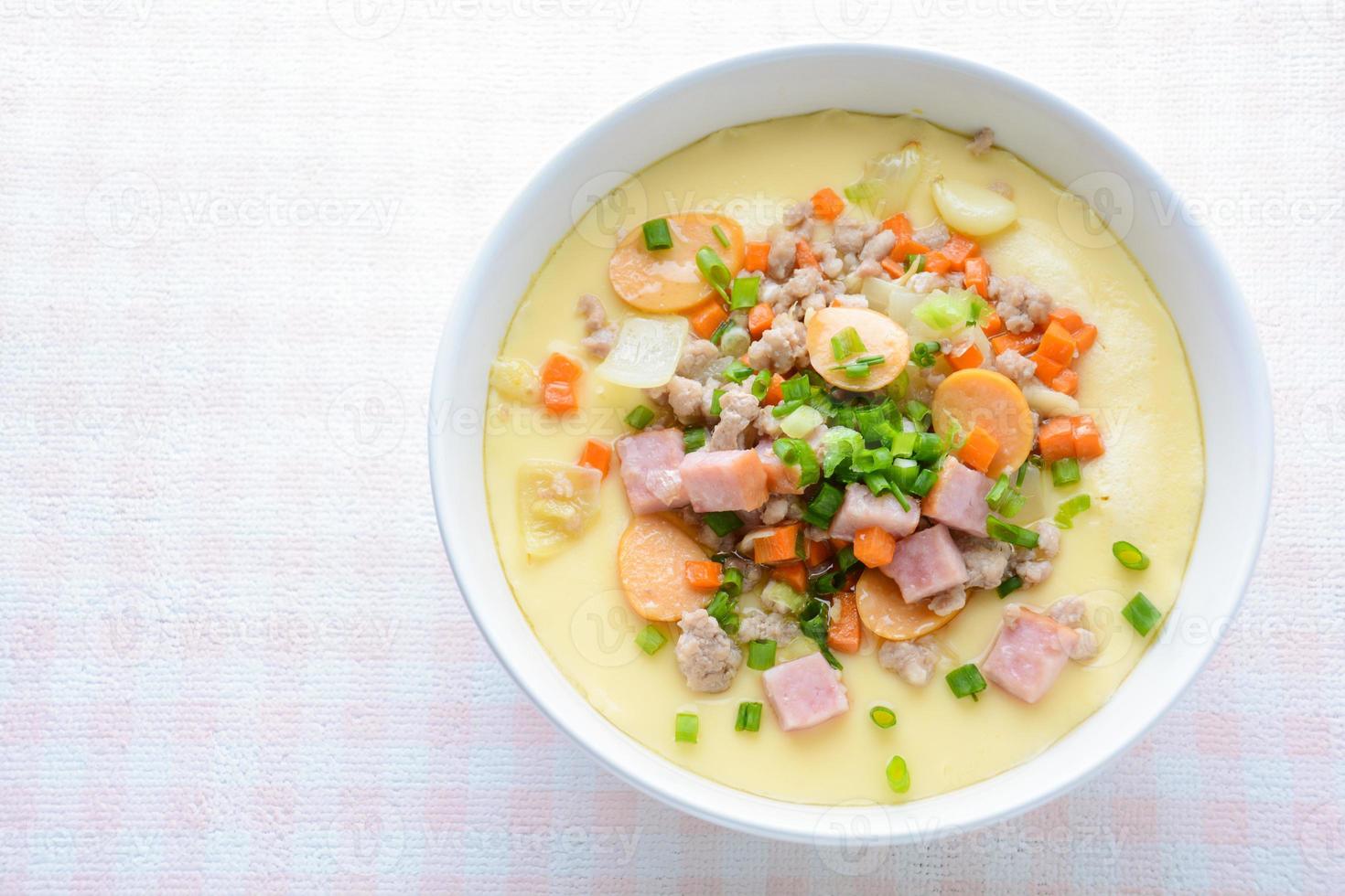 Steamed egg custard cuisine in a white bowl with minced pork, sausage and bacon.  Or Only with egg, water, salt and some sesame oil, you can make this super smooth custard at home. photo