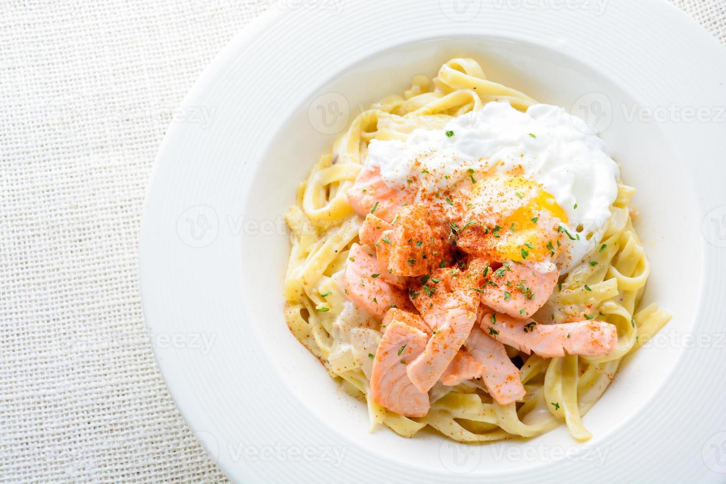 Fettucine with salmon, egg and parmesan cheese, served on white plate. photo