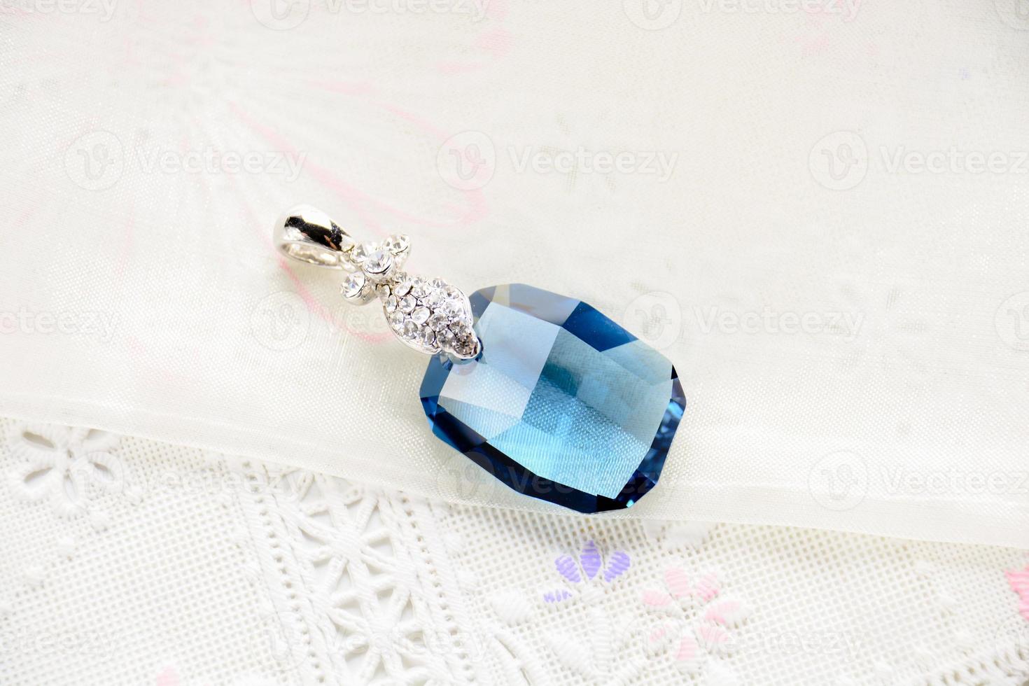 Crystal necklace on white fabric background photo