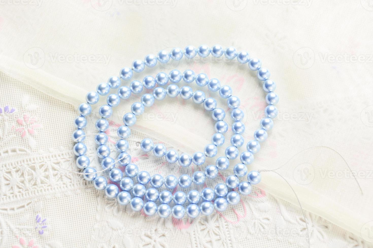 pearl necklace on white fabric background, Close up shot of glass pearls photo