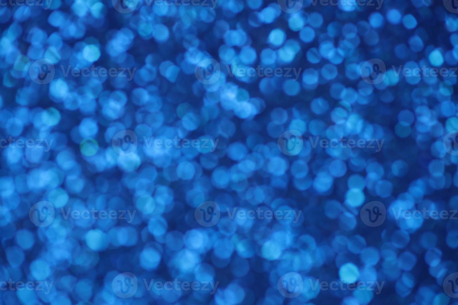 Blue sparkle blurry background with blurred dots texture photo