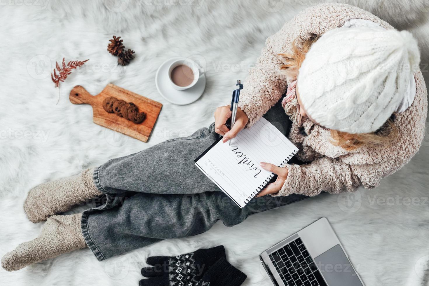 A girl writing winter words on a note book for winter concept background photo