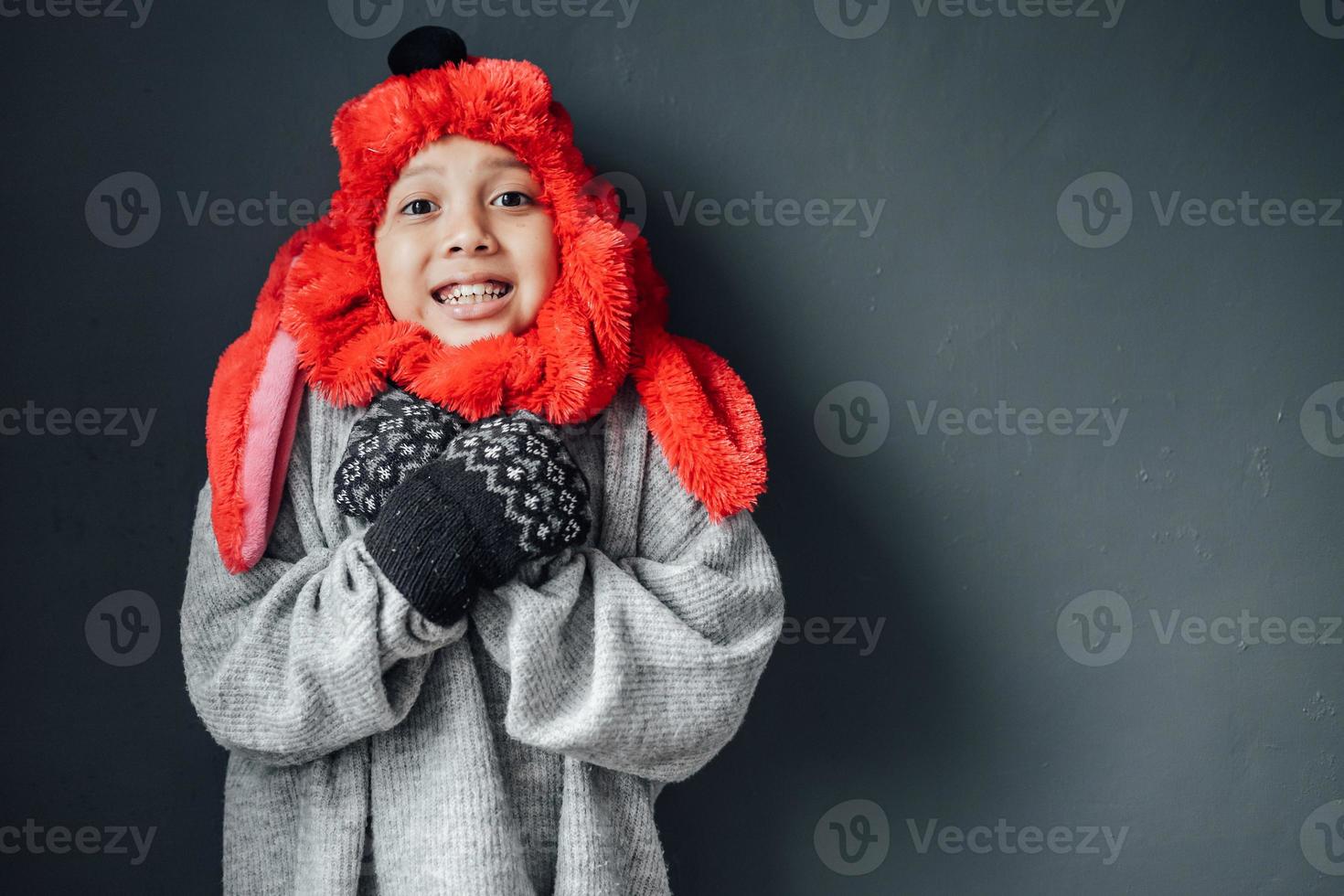 A boy wearing cute winter clothes feeling cold on winter season photo