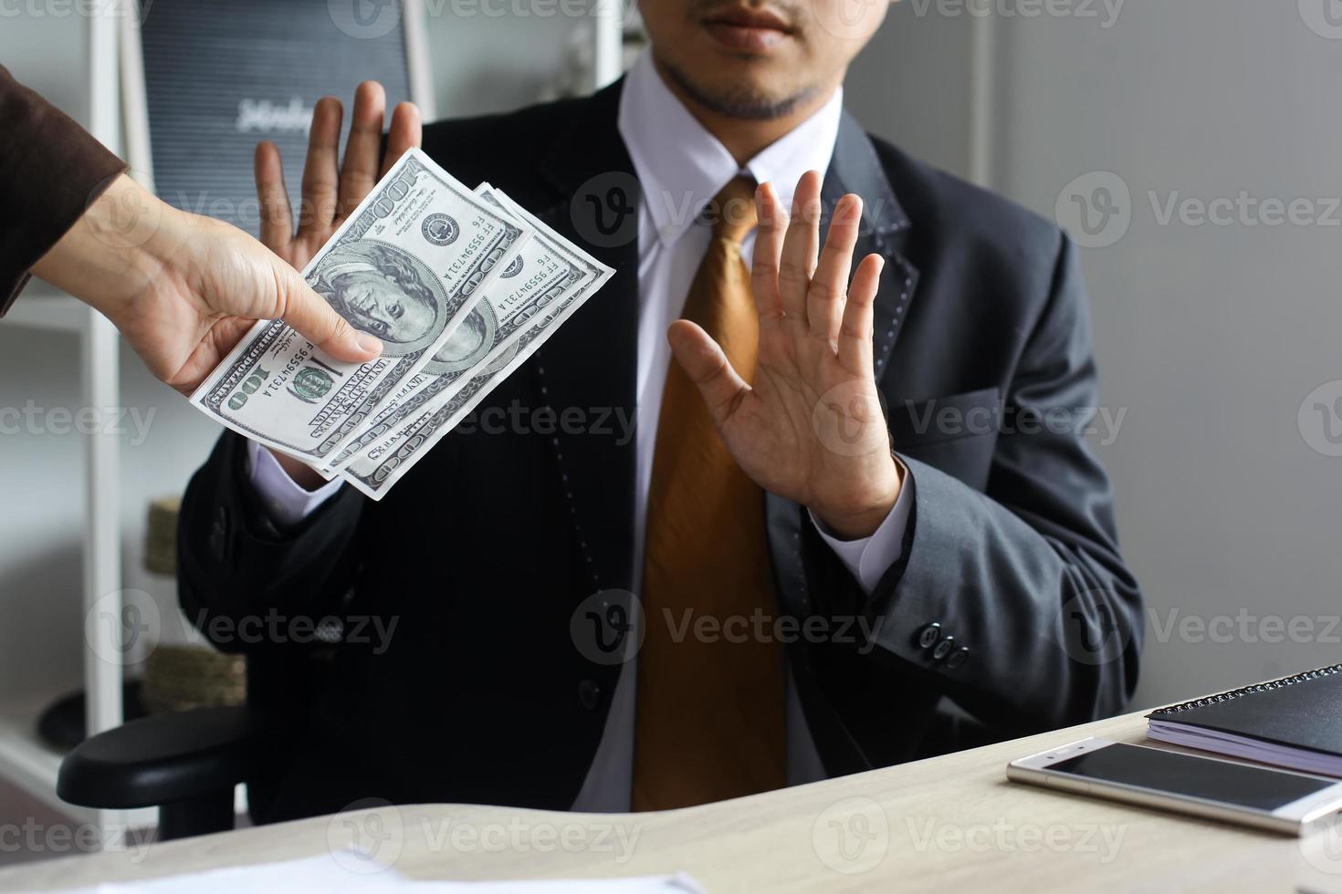 Anti bribery and corruption concept, Business man refusing and don't receive money banknote in envelope offer from business people to accept agreement contract of investment deal. photo