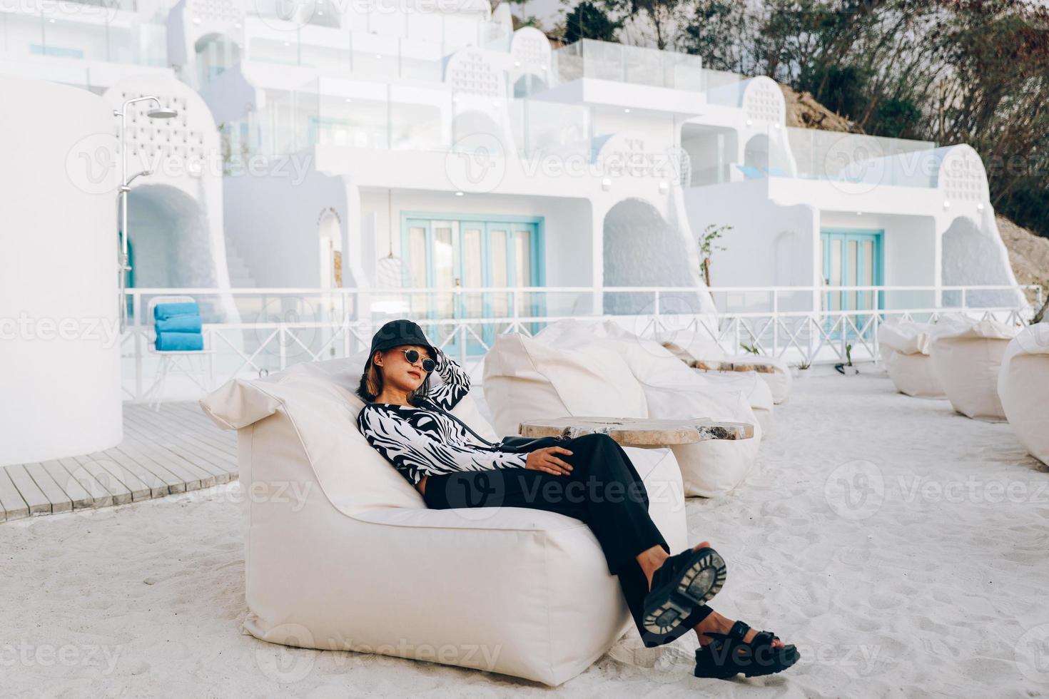 chica hipster recostada en una silla de puf disfrutando de las vacaciones foto